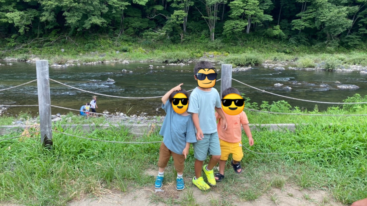 3人の子どもたちの後ろにはキャンプ場の目の前にある川と山